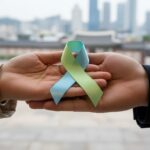 암 환자 의료비 지원을 상징하는 손길과 리본 이미지