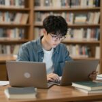 노트북과 책 앞에서 공부하는 이공계 학생의 모습을 상징적으로 표현한 이미지