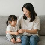 한부모 가정의 엄마와 아이가 함께 웃으며 소파에 앉아 있는 따뜻한 이미지