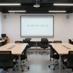 1인 창조기업 지원센터의 깔끔한 공용 사무공간, 독립 책상과 회의실이 보임
